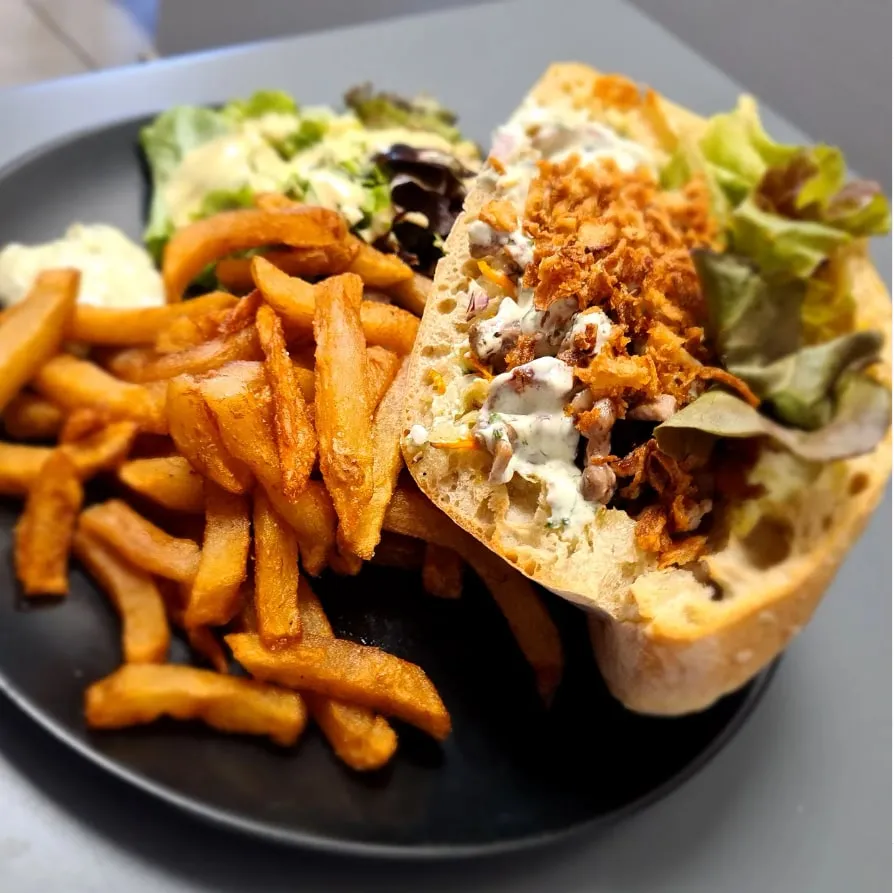 Assiette du restaurant : sandwich garni, frites maison et salade.